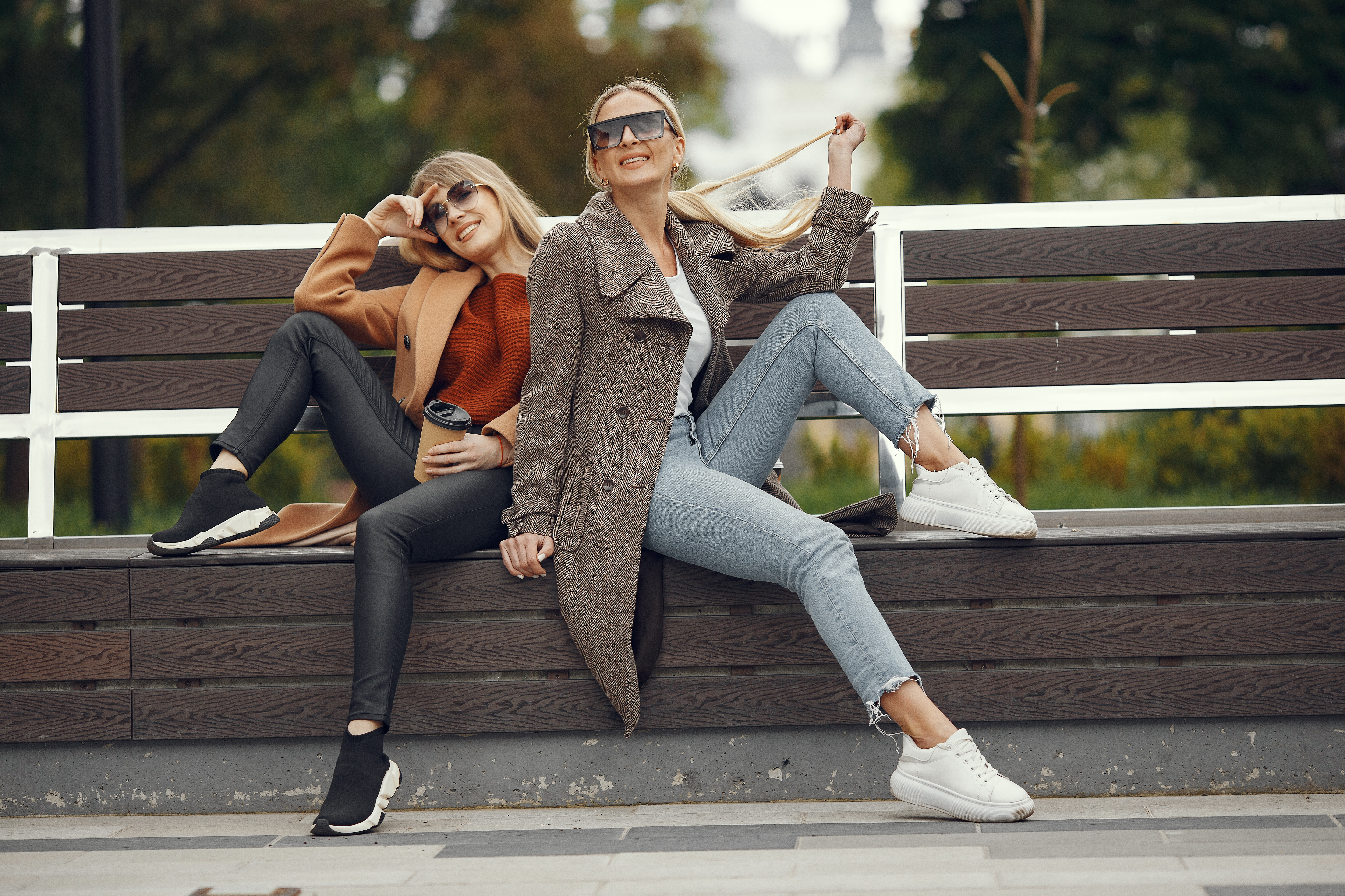 girls sitting in a spring sity and hold coffee in her hand